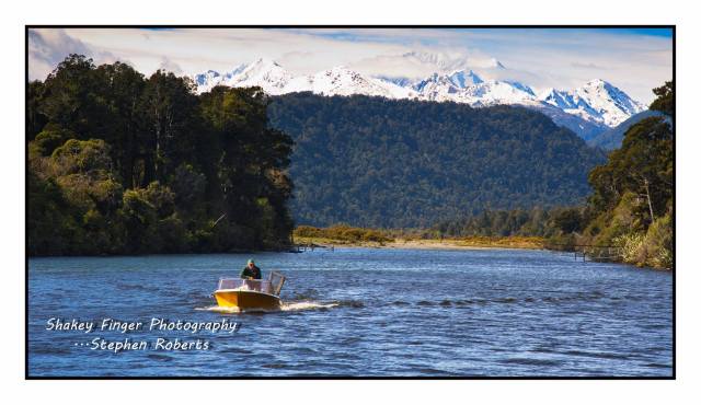 boating down jacobs river with mt cook and southern alps in the background